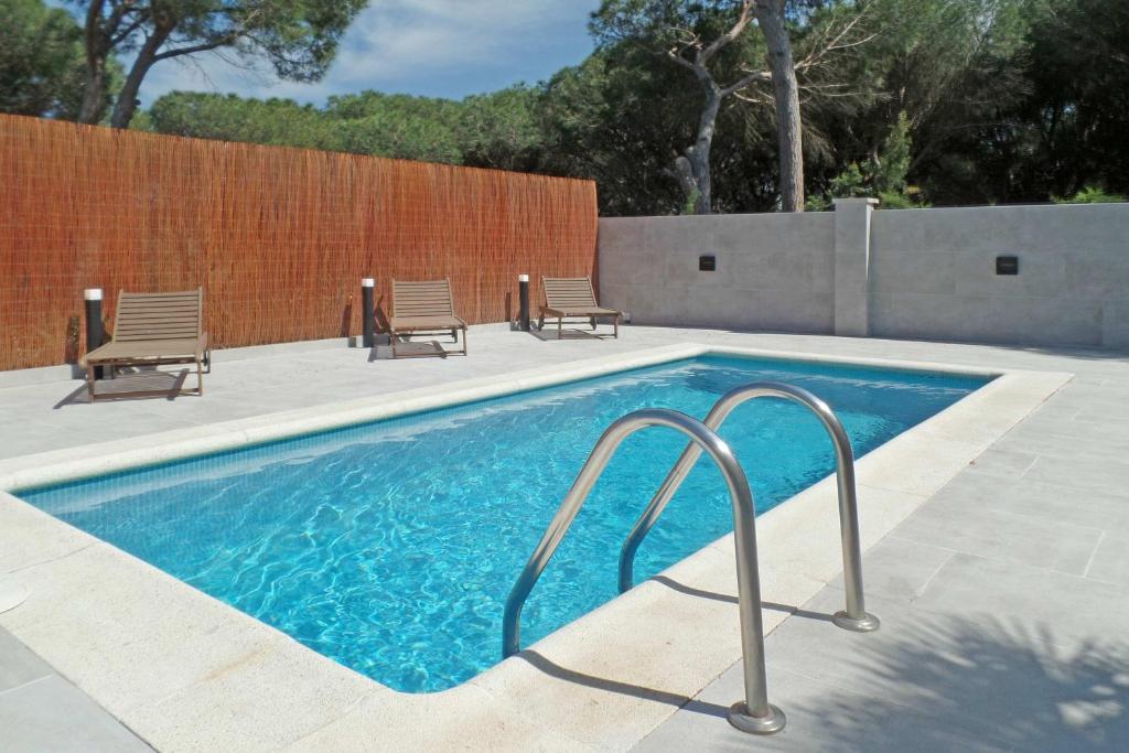 莱斯卡拉Casa Bel Coll的一个带椅子和围栏的游泳池