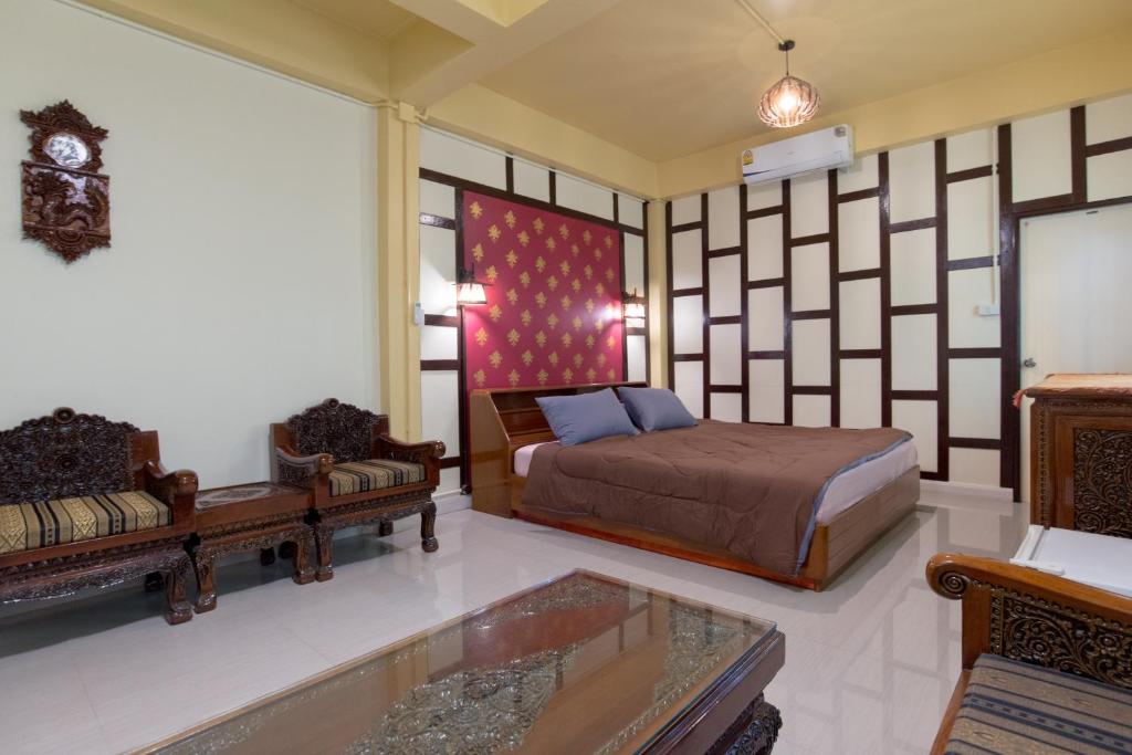 曼谷萨瓦迪原始旅舍 的一间卧室配有一张床、一张沙发和一张桌子