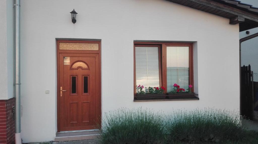 VrbovecApartmán Eva的一座带红色门和两个窗户的房子
