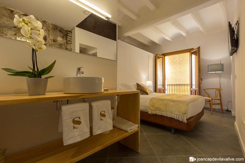 法尔塞特Hotel Secrets Priorat的一间带水槽的浴室和一张位于客房内的床