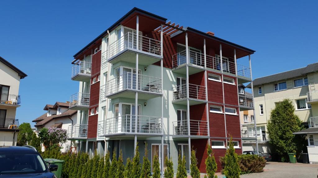 梅尔诺瑞维拉酒店的公寓大楼设有红色和白色的阳台