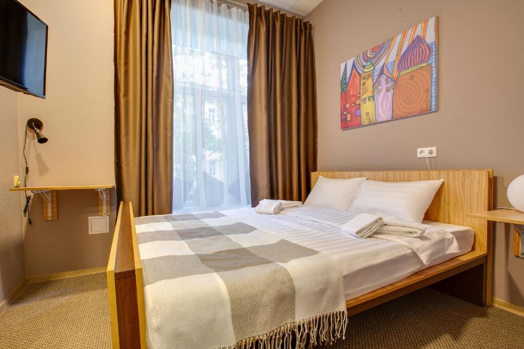 莫斯科阿克塞尔旅舍的一间卧室设有一张大床和窗户