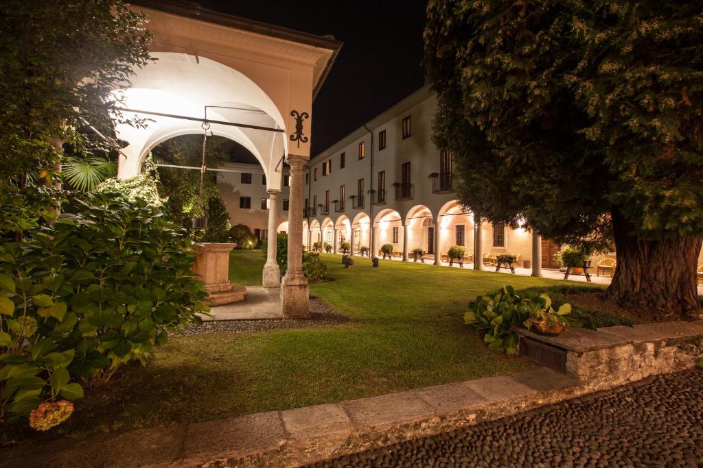 韦尔巴尼亚Il池沃斯特罗酒店的一座建筑物的庭院,晚上有棵树