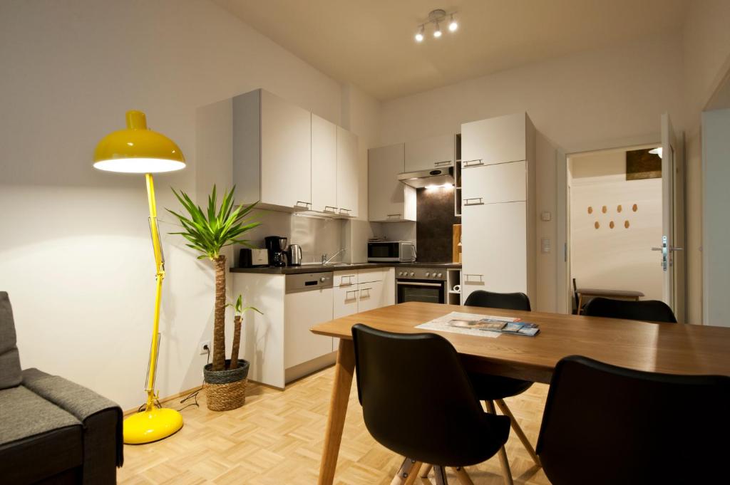 格拉茨纽堡伽斯城市公寓的厨房以及带桌椅的用餐室。