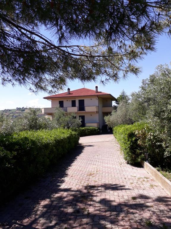 MutignanoLa Foresteria- Azienda agricola Garra的一座有红屋顶和砖车道的房子