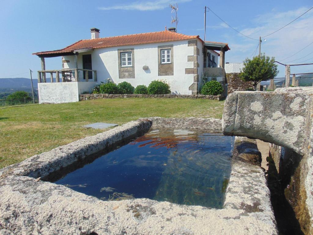 维拉·诺瓦·达·塞尔维尔Casas da Loureira - Casa do António e Pascoal的房屋前的水池