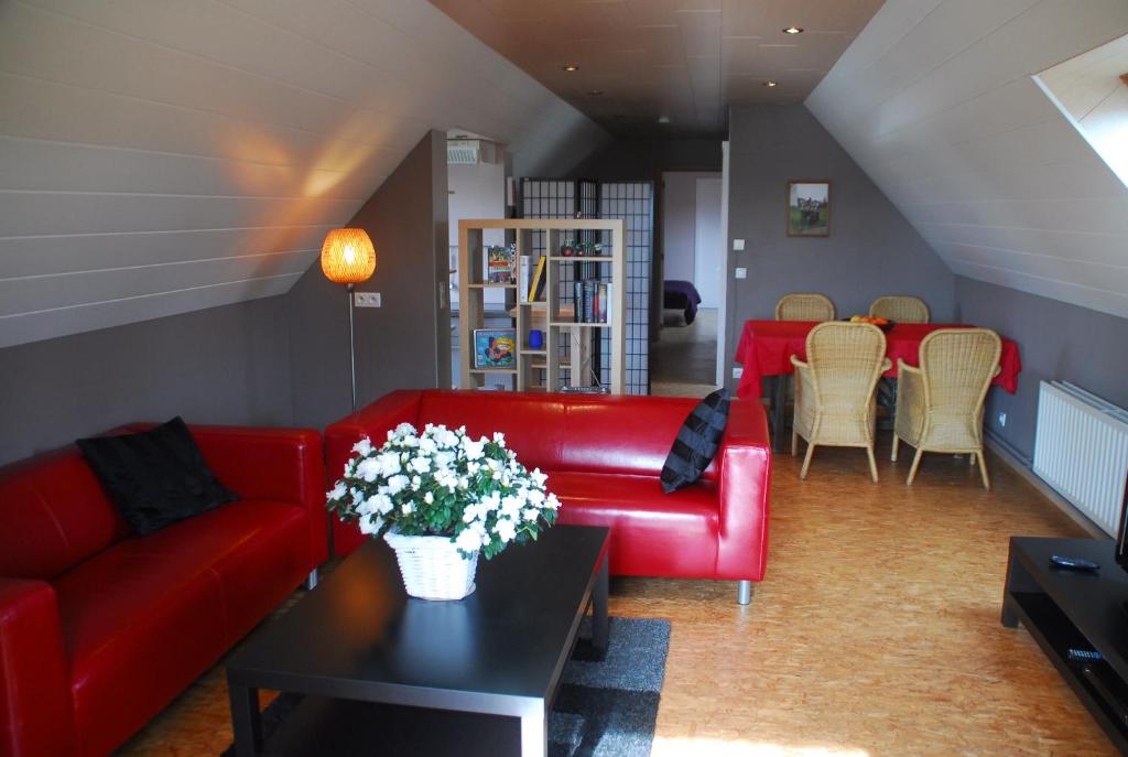Ertvelde德罗斯莫乐恩酒店的客厅配有红色的沙发和桌子