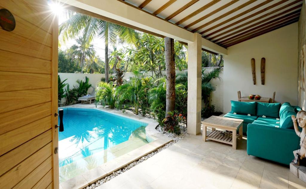 吉利特拉旺安森南私人别墅的一个带游泳池和蓝色沙发的庭院