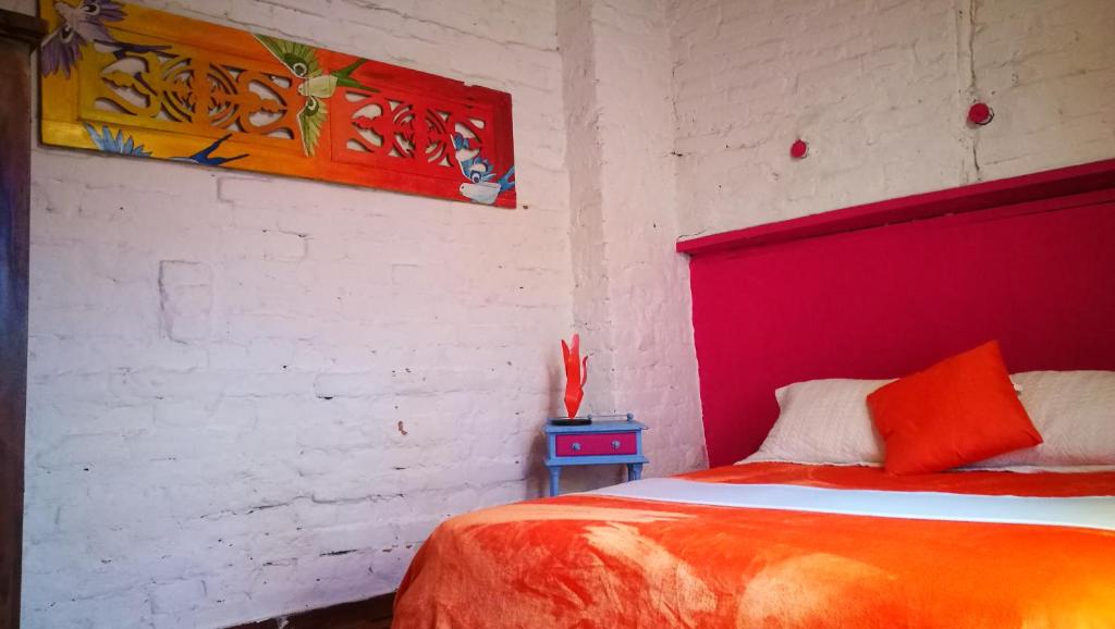 波哥大利马利蒙烛火旅馆的一间卧室配有一张红色床头板的床