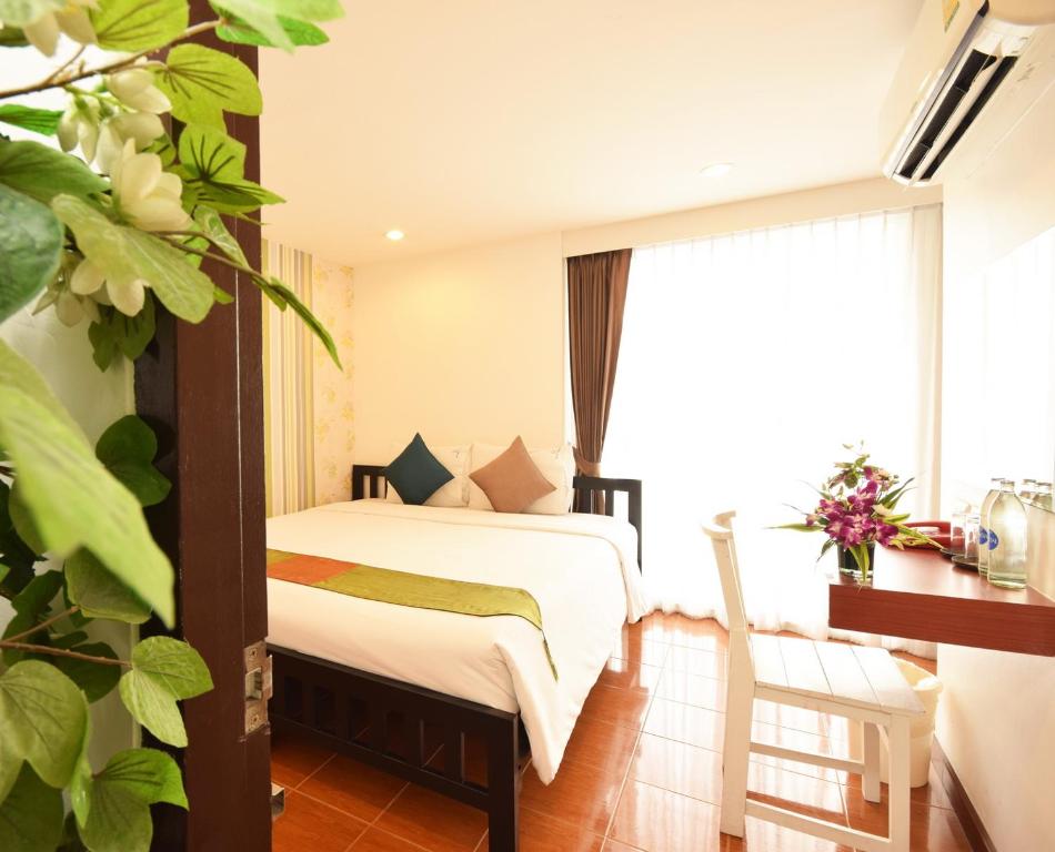 曼谷拉查达毕莉斯酒店的一间卧室设有一张床和一个大窗户