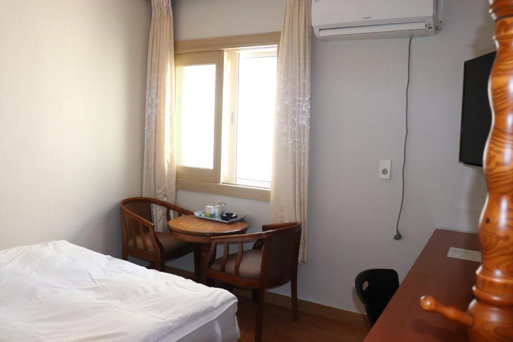 济州市奥拉星汽车旅馆的客房设有床、桌子和窗户。