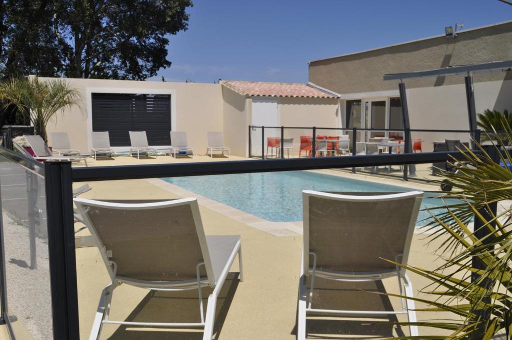 皮耶尔拉特凯门酒店的一座房子旁的游泳池,配有两把椅子和一张桌子