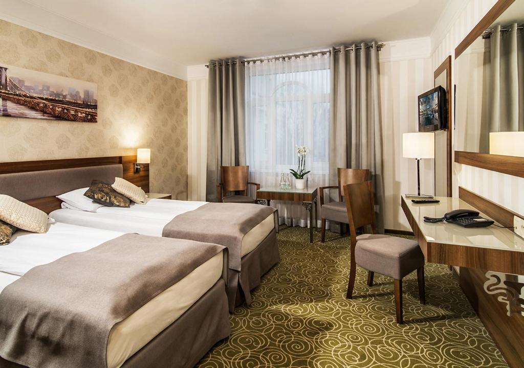 华沙华沙​​机场洛德酒店的酒店客房配有两张床和一张书桌