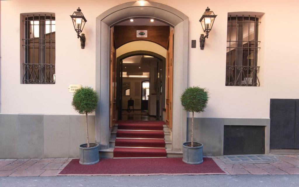 博洛尼亚旅游酒店的两株盆栽植物的建筑物入口