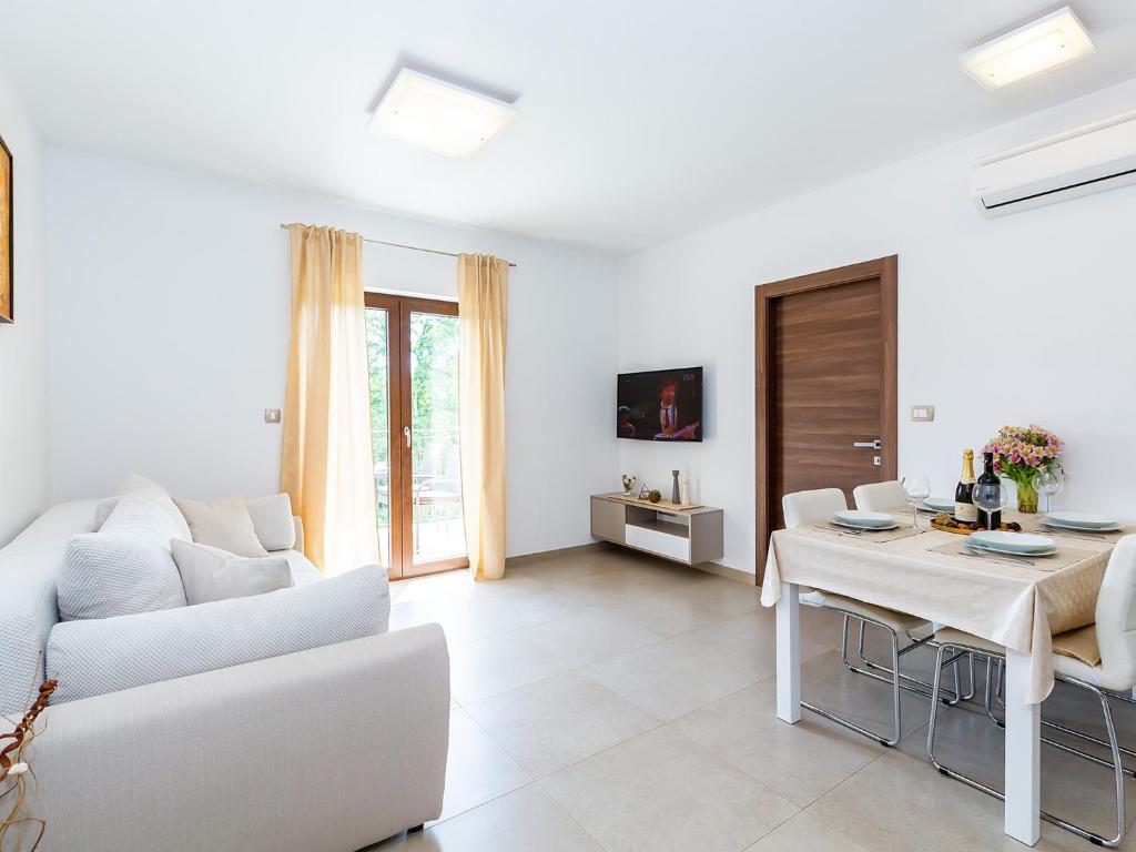 波雷奇Apartments Gioia的白色的客厅配有白色的沙发和桌子