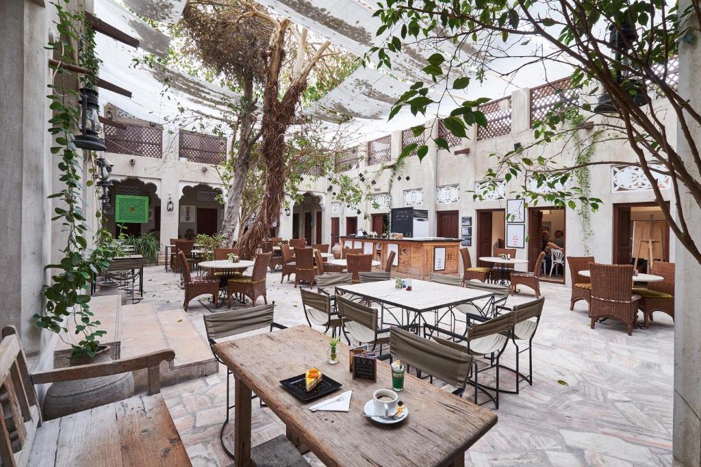 迪拜XVA艺术酒店的庭院配有桌椅和一棵树