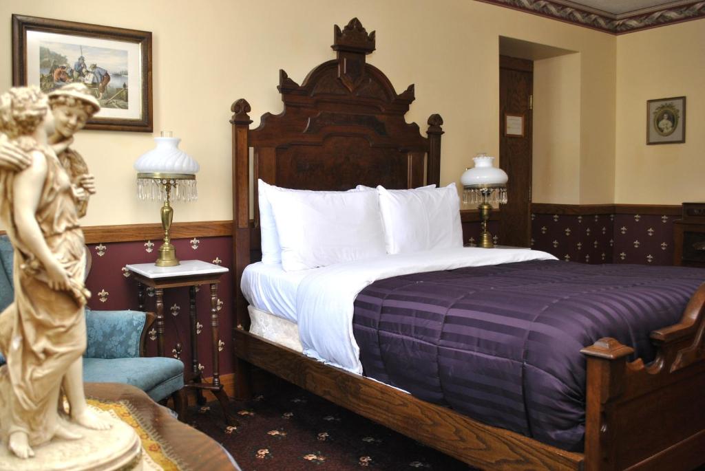 米勒斯堡米勒斯堡酒店的卧室配有一张床,房间内设有雕像