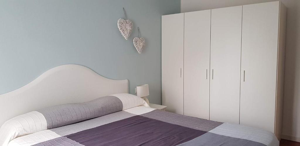 莱科Le Casette Di Osvaldo的白色卧室配有一张床和白色橱柜