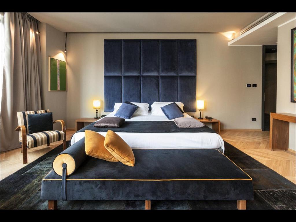 罗马特里维霍酒店 的大卧室配有一张带蓝色枕头的大床