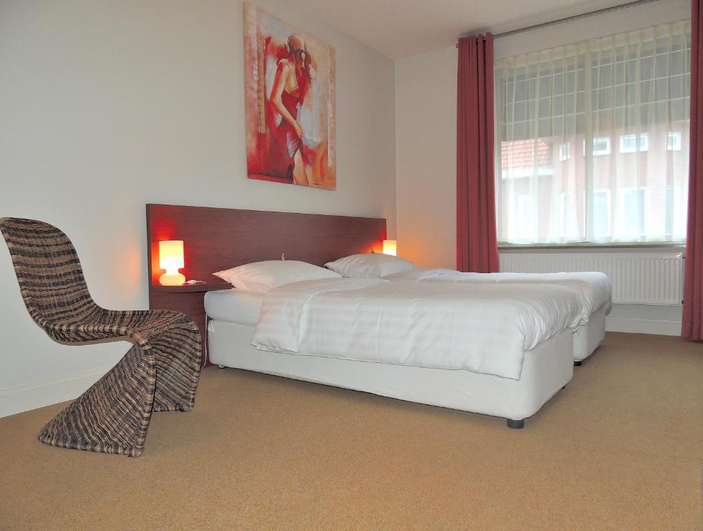 Poppel米克帕伯酒店的卧室配有白色的床和椅子