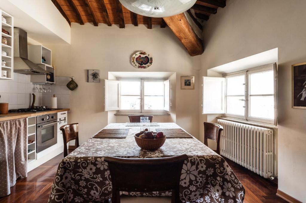 卢卡Lucca sui tetti的厨房配有一张桌子,上面放着一碗水果