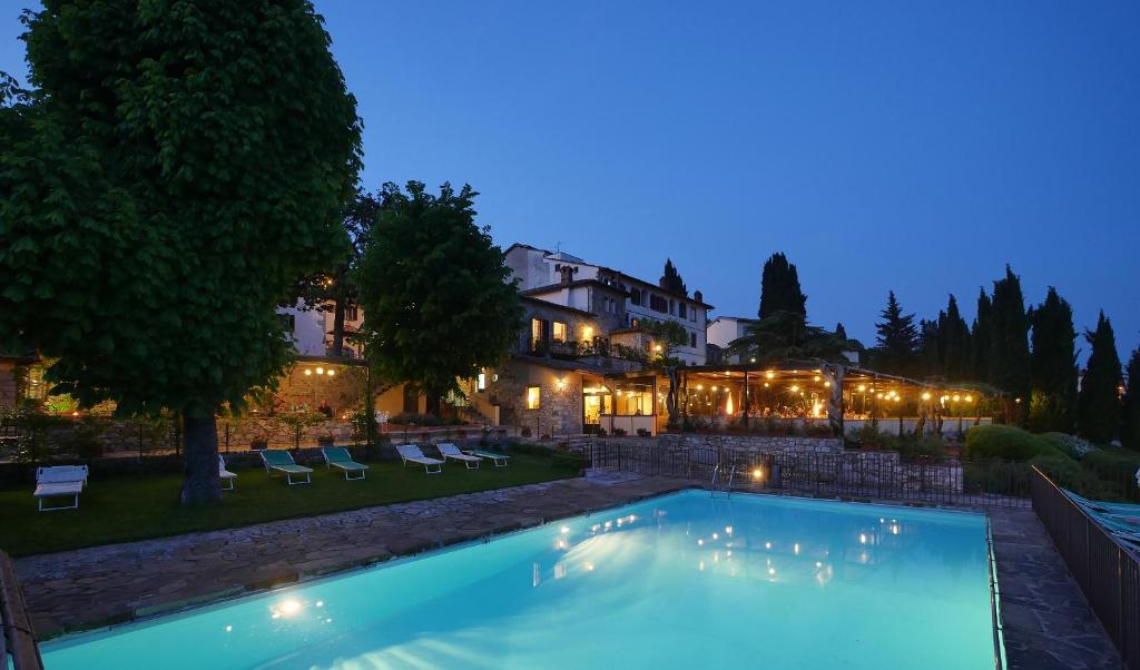拉达-因基安蒂Relais Vignale & Spa的夜间在房子前面的游泳池