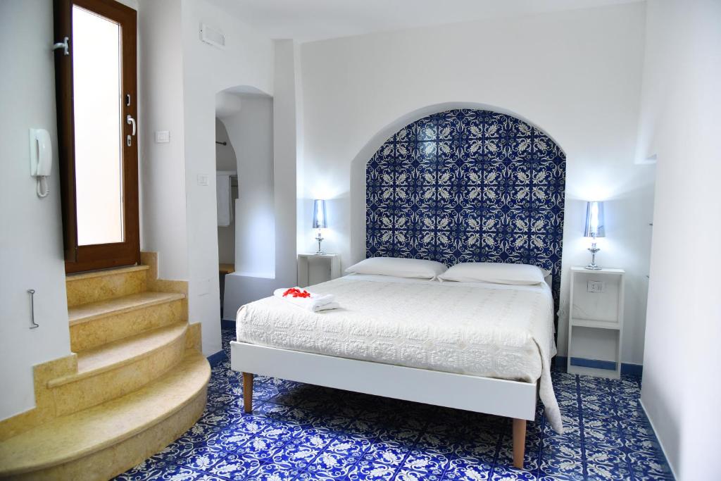 加利波利B&B Corte Casole的一间卧室配有一张带蓝色床头板和楼梯的床。