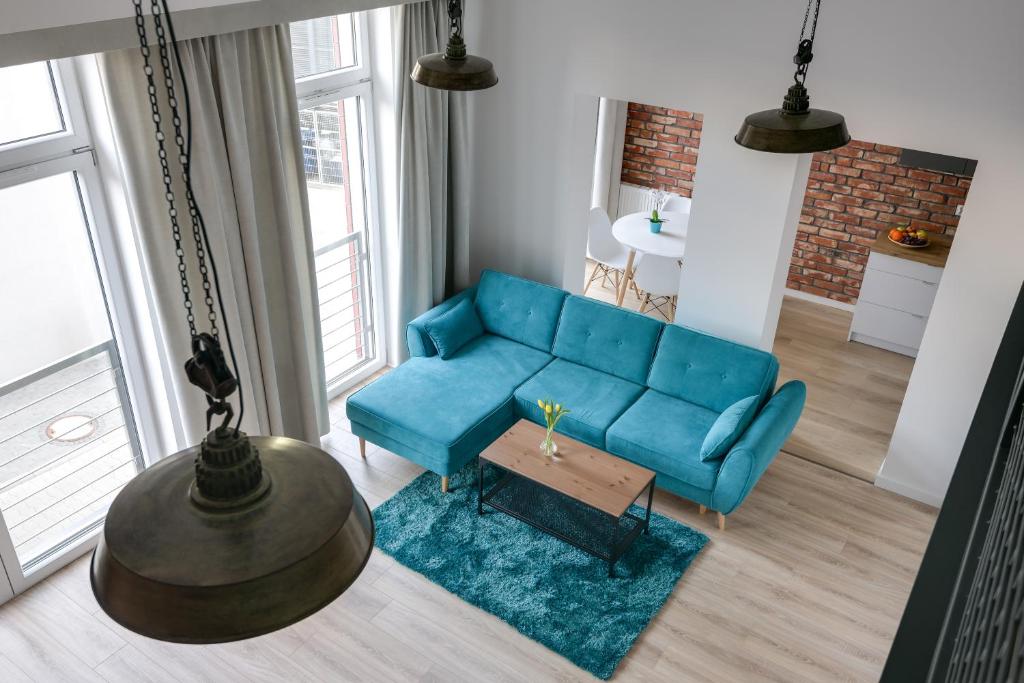 弗罗茨瓦夫Easy Apartments Wrocław的客厅配有蓝色的沙发和桌子