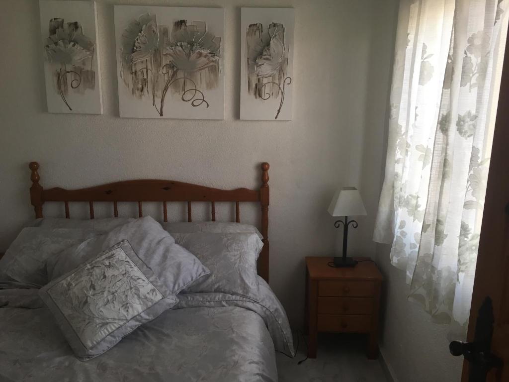 拉马丽娜Casa Phoenix Bed & Breakfast的卧室配有一张床,墙上有三幅照片