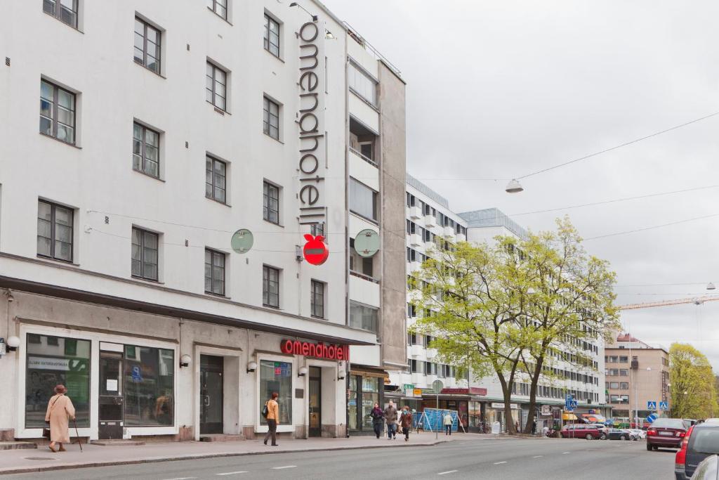 图尔库Omena Hotel Turku Humalistonkatu的白色的建筑,旁边标有标志