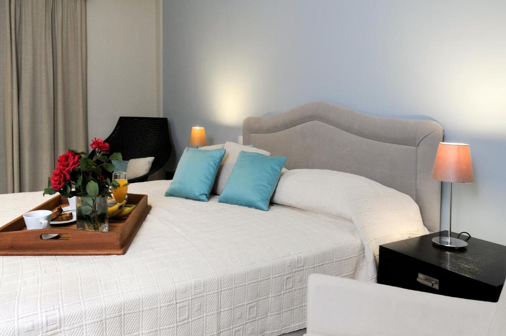 Milopótamos雅典娜酒店的一间卧室配有白色床和蓝色枕头