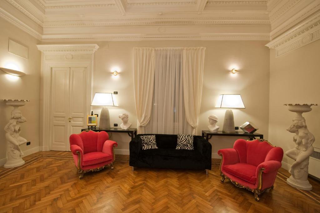 佛罗伦萨隆巴尔多住宿加早餐旅馆的客厅配有2把红色椅子和1张沙发