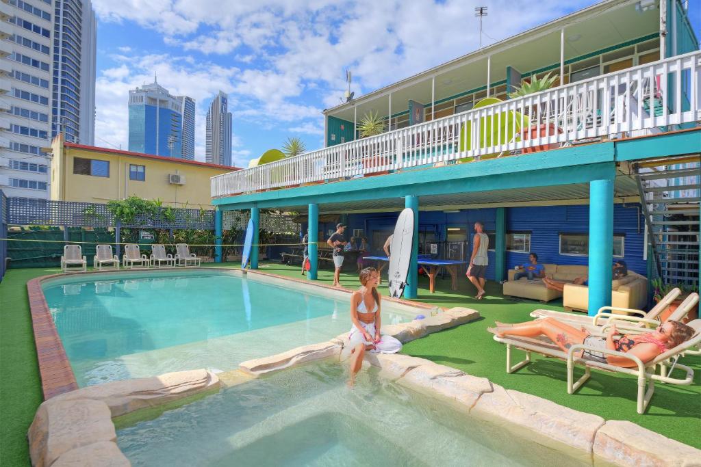 黄金海岸Backpackers In Paradise 18-35 Hostel的坐在酒店游泳池中的女人
