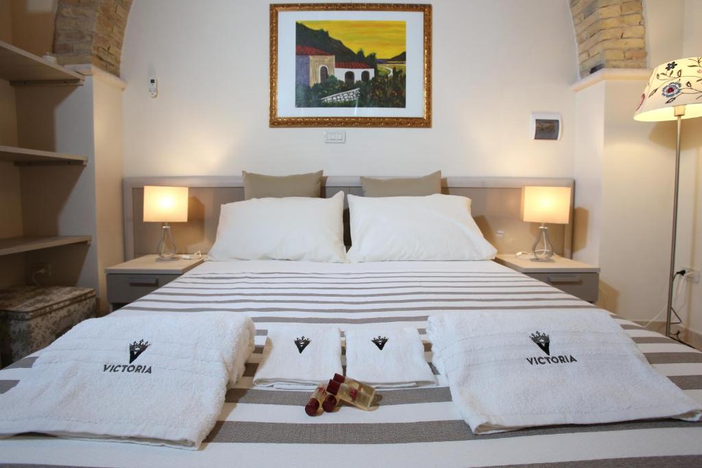 泰尔莫利Victoria Royal Apartments的一间卧室配有一张床,上面有两条毛巾