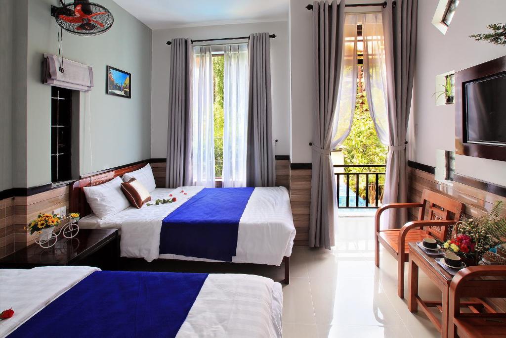 会安An Thinh Homestay的酒店客房设有两张床和窗户。