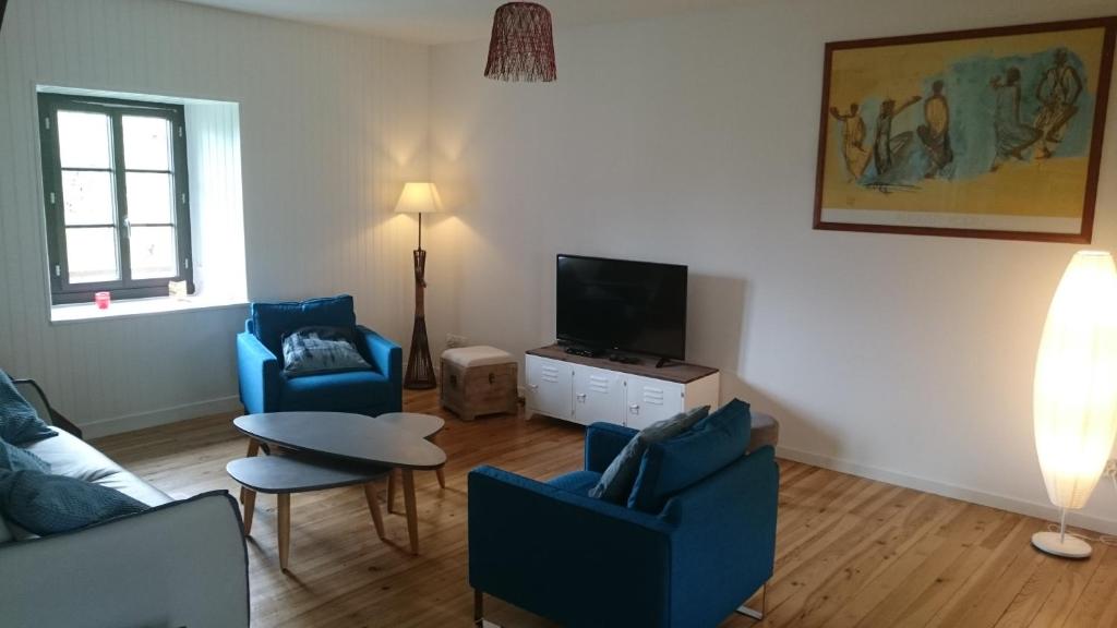 卢登维耶尔Maison de village/Appartement de charme avec extérieur的客厅配有2把蓝色椅子和电视