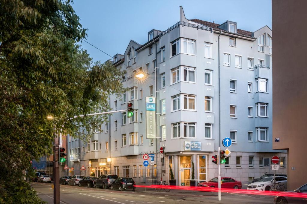 曼海姆Sure Hotel by Best Western Mannheim City的城市街道上的白色建筑,有交通灯