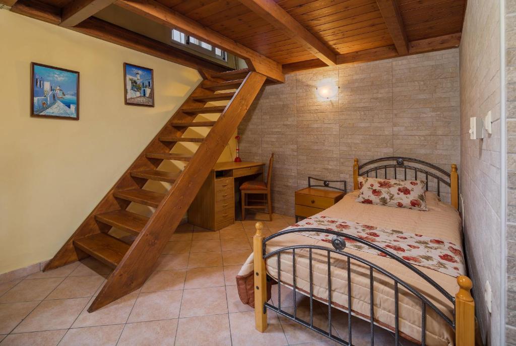 KatastárionMartha's House的一间卧室设有一张床和木制楼梯。