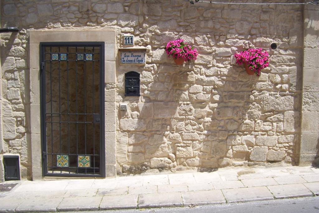 拉古萨La Dimora di Angela的石头建筑,有门和鲜花