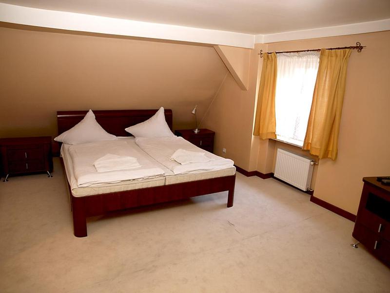新苏尔Hotel Polonia的一间卧室配有一张带白色床单的床和一扇窗户。