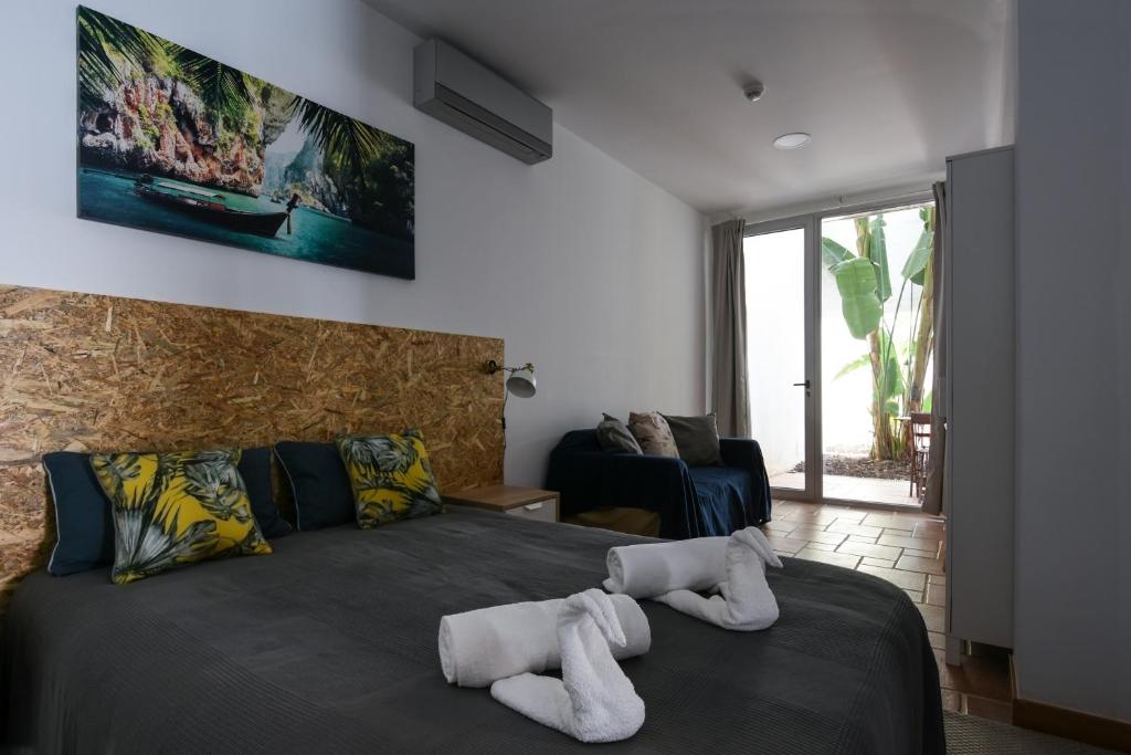 维拉·雷阿尔·德·桑托亚Pé na Areia - Guest House的一间卧室配有带毛巾的床