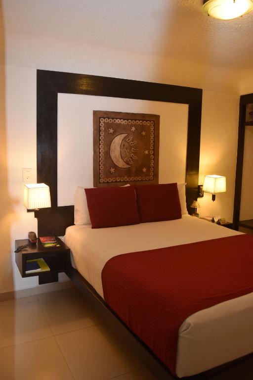 比亚埃尔莫萨巧克酒店的一间卧室配有一张带红色枕头的大床