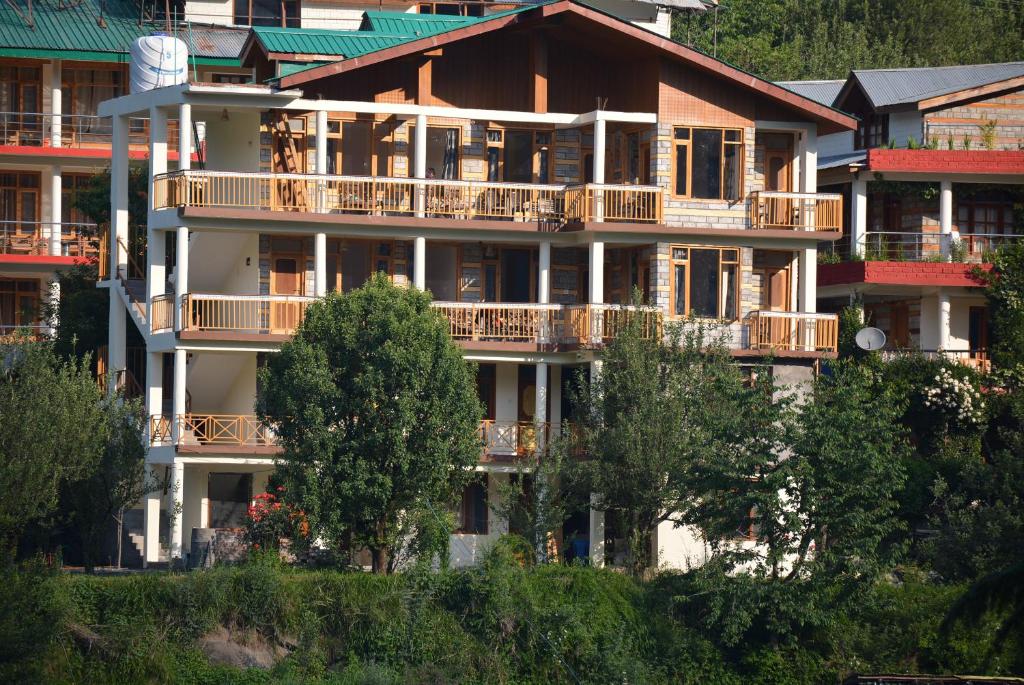 马拉里Himalaya Cottage的带阳台和树木的大型公寓大楼
