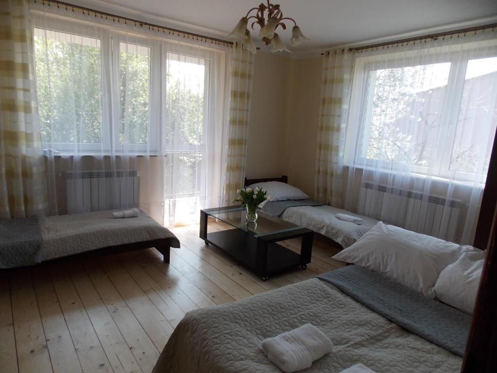 扎托尔Noclegi Zator的一间卧室设有三张床、一张桌子和窗户。