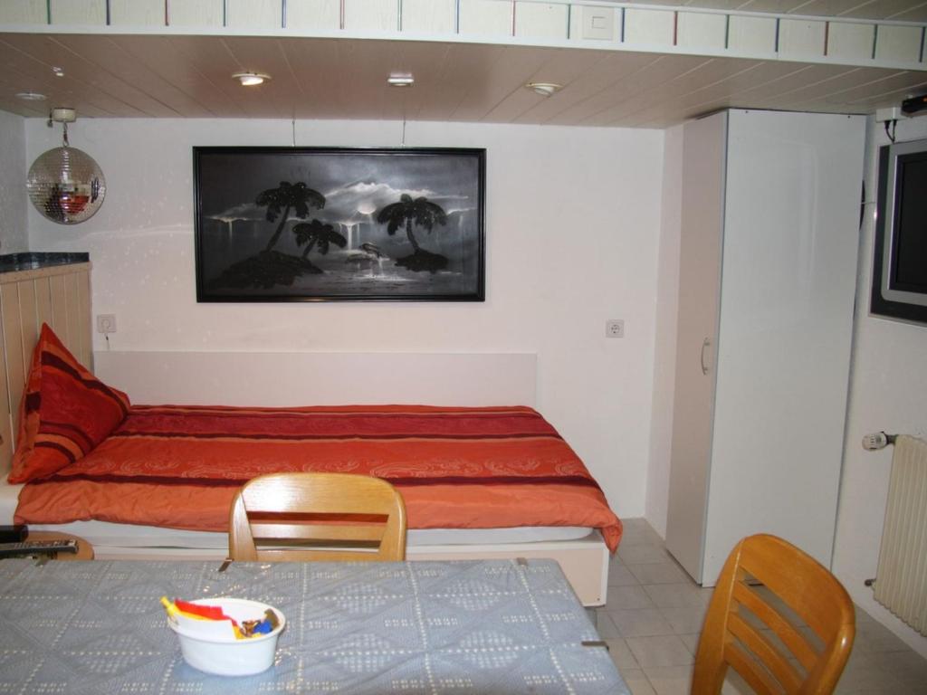 莱茵河畔威尔Gästezimmer Jülich的卧室配有一张床和一张桌子及椅子