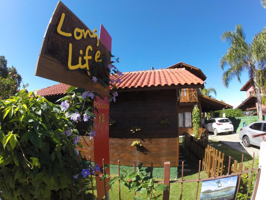 弗洛里亚诺波利斯Long Life Campeche-Pousada的木屋前的标志