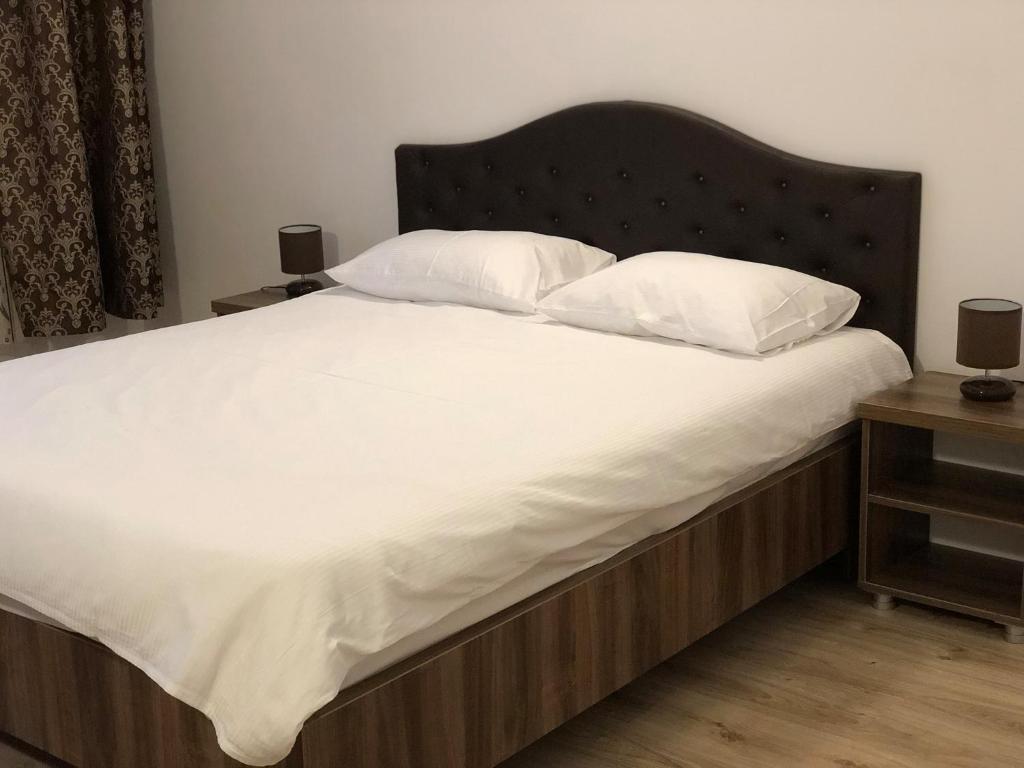 旧瓦马Vila Natalia的一张配有白色床单和枕头的大床