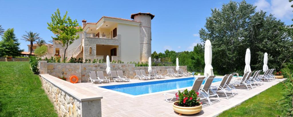 希维利Rahona Villas的一座别墅,设有游泳池、椅子和一座房子