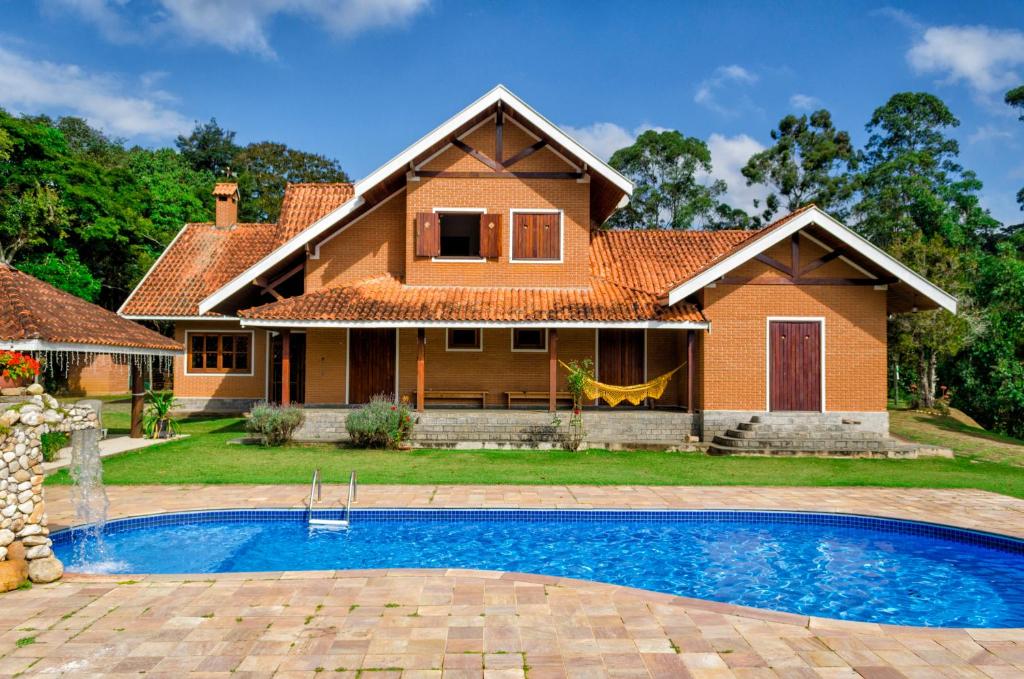 圣安东尼奥-杜皮尼亚尔Pousada Casa Da Colina的房屋前有游泳池的房子