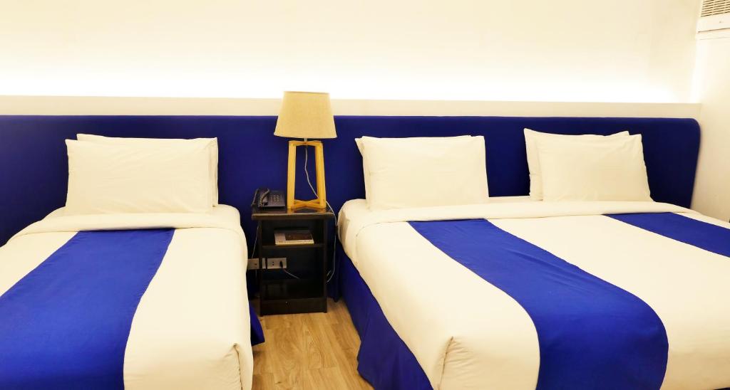 伊洛伊洛GT Hotel Jaro的蓝色和白色的客房内的两张床